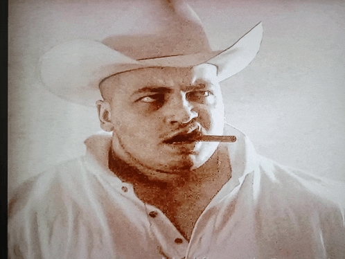 a man wearing a cowboy hat and smoking a cigar