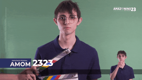 a man holding a clapper board with the number 2323 on the bottom