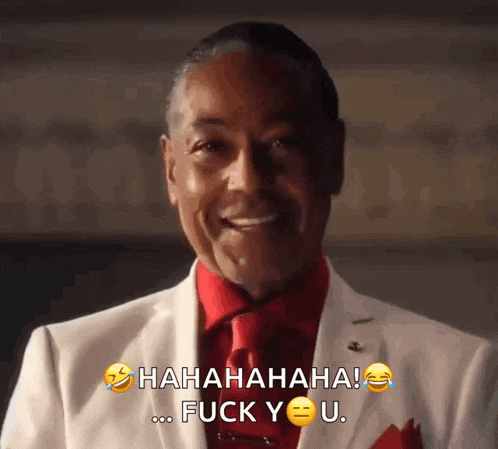 a man in a white suit and red tie is laughing