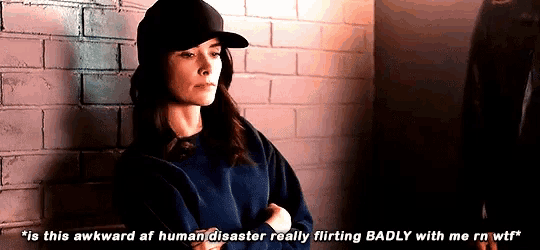 a woman leaning against a brick wall says " is this awkward af human disaster