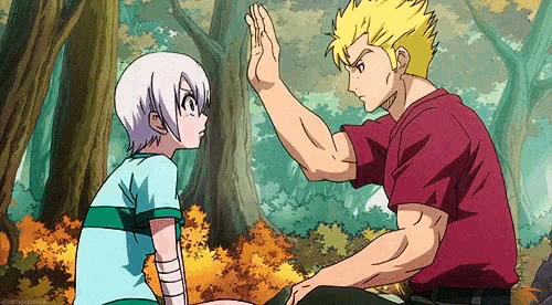 a man and a boy are giving each other a high five while sitting in the woods .