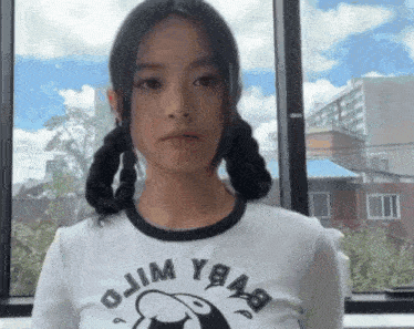 a girl with pigtails is wearing a t-shirt that says ojim ybab