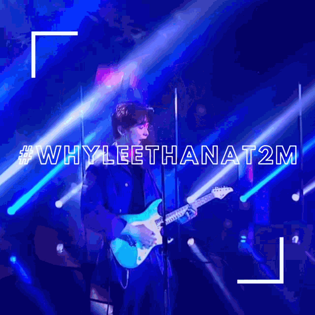 a man playing a guitar on a stage with whyleethanat2m written in white letters