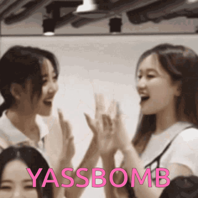 a group of young women giving each other a high five with yassbomb written on the bottom