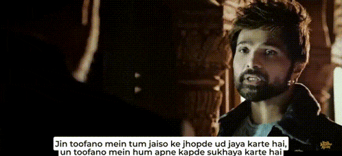 a man with a beard is talking to another man in a movie .
