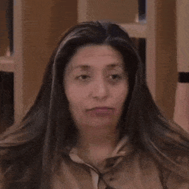 a woman is sitting on a couch wearing headphones and making a face .