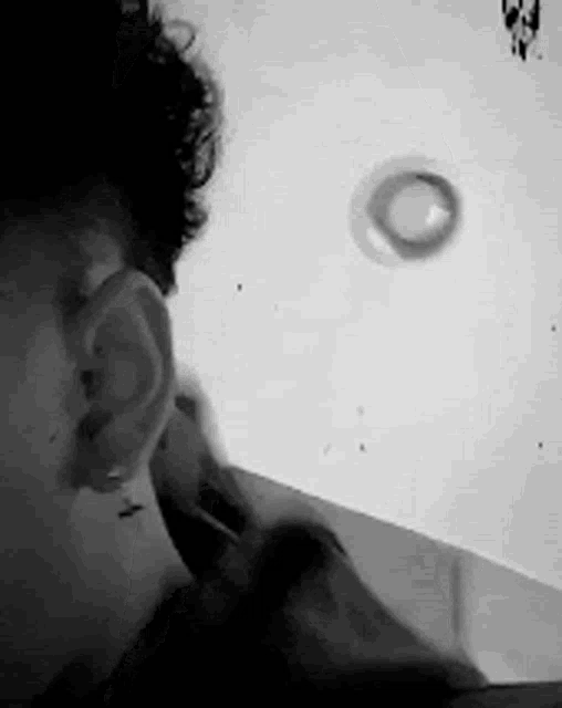 a black and white photo of a man 's ear