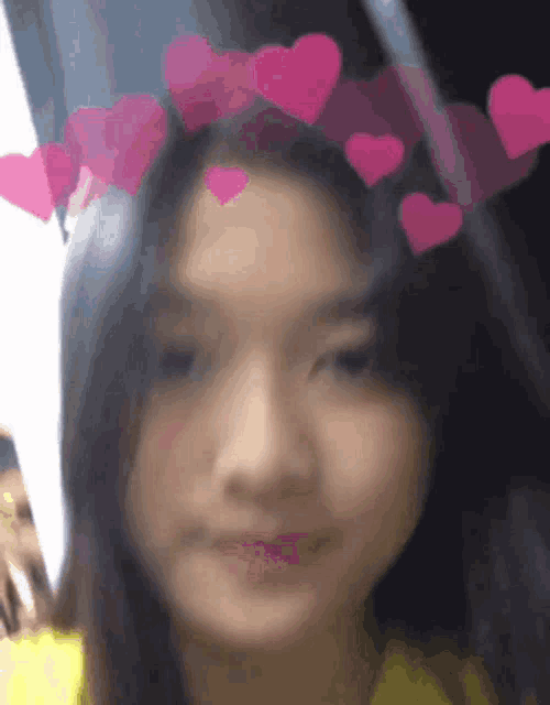 a girl wearing a crown of pink hearts on her head .