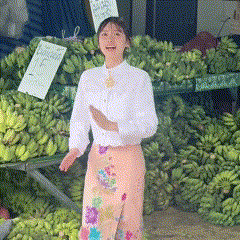 a woman standing in front of a pile of bananas