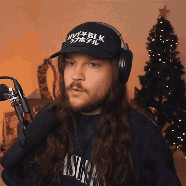 a man wearing headphones and a hat that says nvx blk
