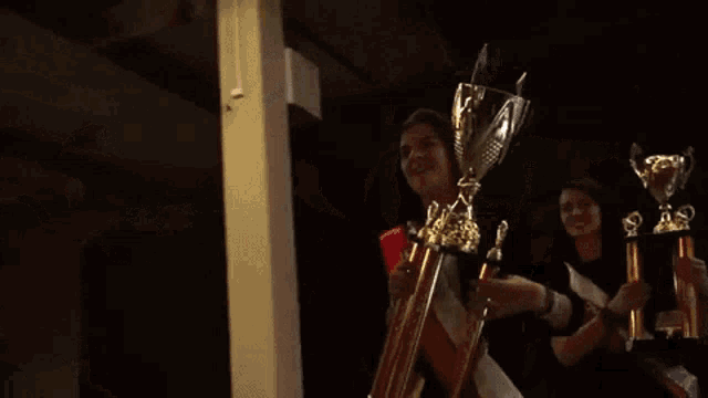 a woman in a graduation cap and gown is holding a trophy in her hands