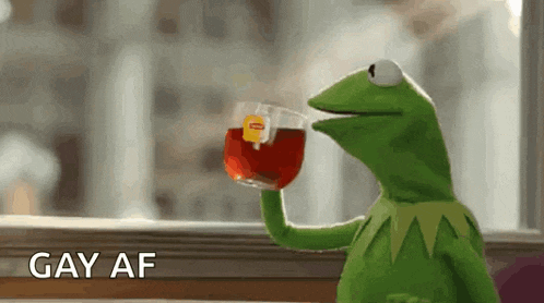 kermit the frog is drinking a cup of tea from a lipton bag .
