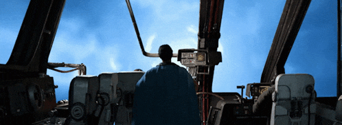 a man in a blue cape is standing in front of a sign that says " emergency exit "