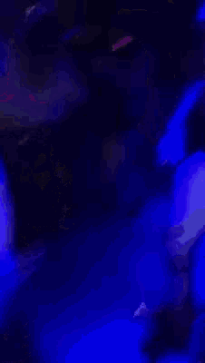 a man wearing a bandana and a black t-shirt is drinking from a glass .