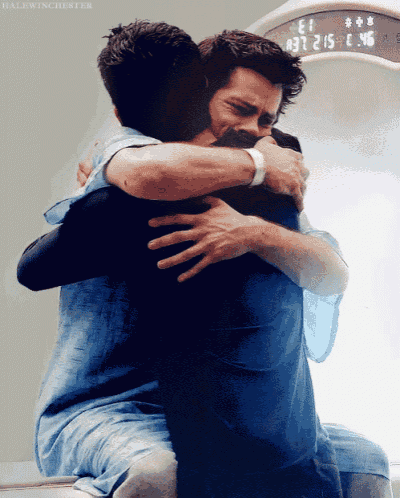 two men hugging each other in front of a clock that reads 1:37