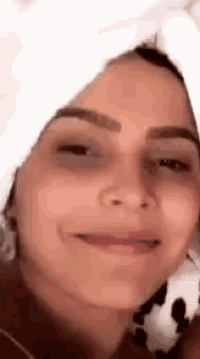 a close up of a woman wearing a white towel on her head .