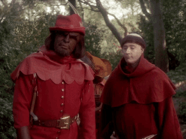 a man in a red costume stands next to another man