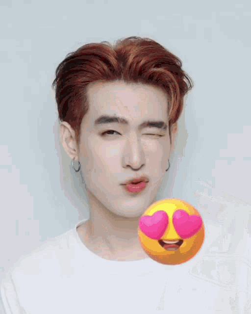 a man with long red hair has a heart shaped smiley face in front of him