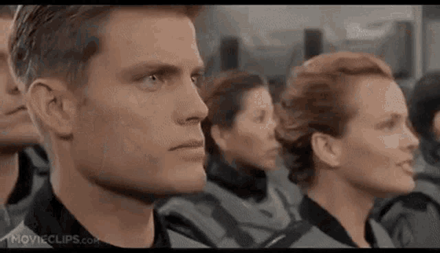 a man and a woman are sitting in a row in a room .