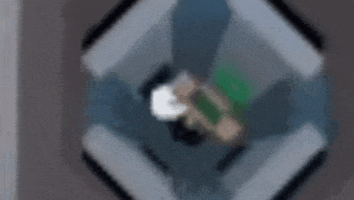 a blurry picture of a person laying on a bed with a green blanket .