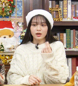 a woman wearing a white hat and a sweater is sitting at a table .