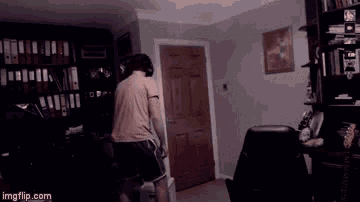 a man in headphones stands in a dark room with a watermark that says imgflip.com at the bottom