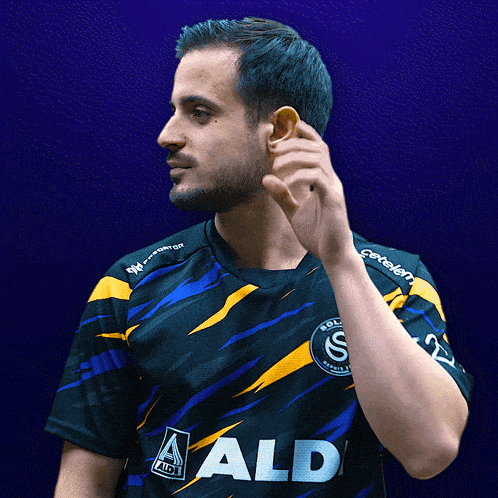 a man wearing a black and yellow shirt with the word aldi on it