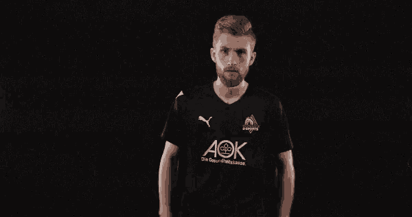 a man wearing a black shirt with aok written on it