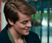 a close up of a person 's face with a fence in the background