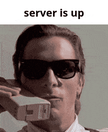 a man wearing sunglasses is holding a piece of paper in his mouth with the words server is up below him