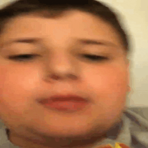 a close up of a boy 's face with his eyes closed and his mouth open