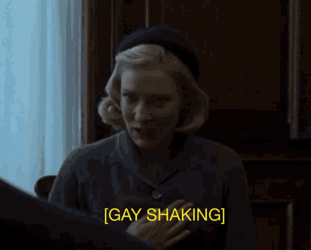 a woman in a dark room says gay shaking in yellow letters