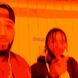 two men are standing next to each other and one of them is pointing at the camera with the word gang written above them