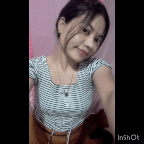 a girl in a striped shirt is taking a picture of herself