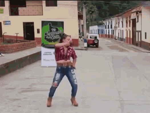 a woman dancing in front of a sign that says santander on it
