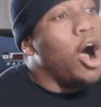 a close up of a man 's face with his mouth open and his tongue out .