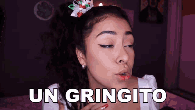 a woman with a bow in her hair is making a face and says un gringito
