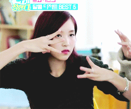 a woman with red hair making a peace sign in front of a sign that says fire best 5