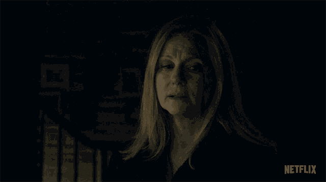 a woman in a dark room with the word netflix on the bottom