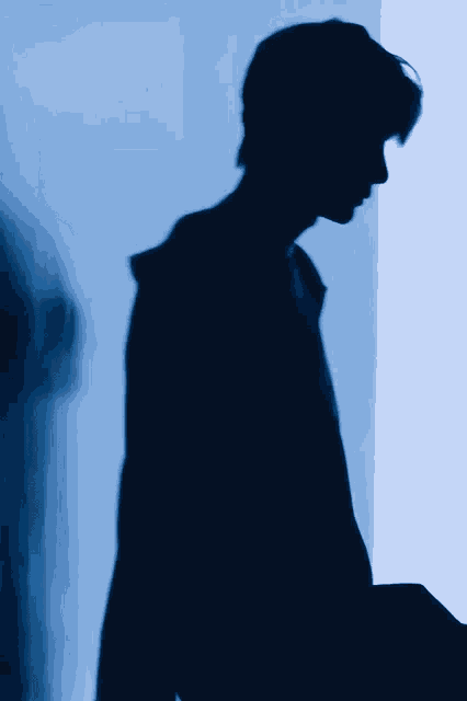 a silhouette of a person in a dark room