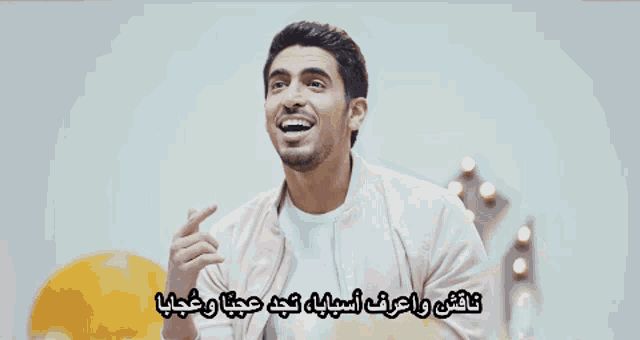 a man with a beard is smiling with arabic writing above him
