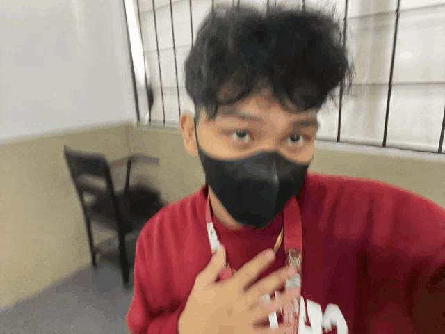 a man wearing a black mask and a red shirt with the letter a on it