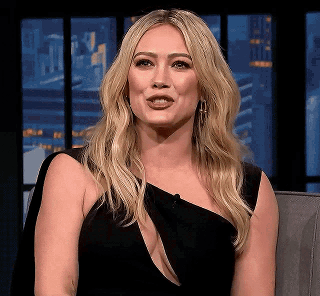 a woman in a black dress with a plunging neckline