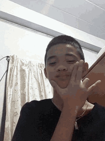 a young man making a peace sign with his hand
