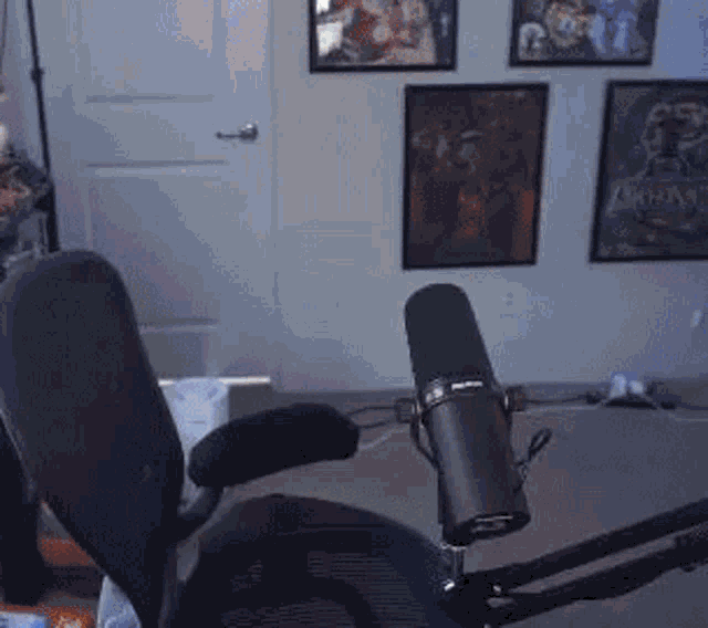 a microphone is sitting in front of a chair in a room with posters on the wall .