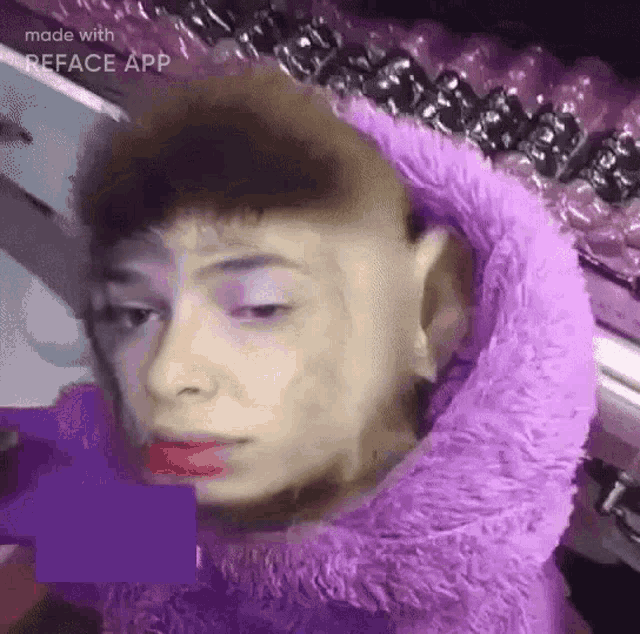 a close up of a person 's face with a purple blanket around their neck .