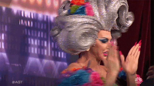 a woman in a colorful costume with the hashtag #agt on the bottom right