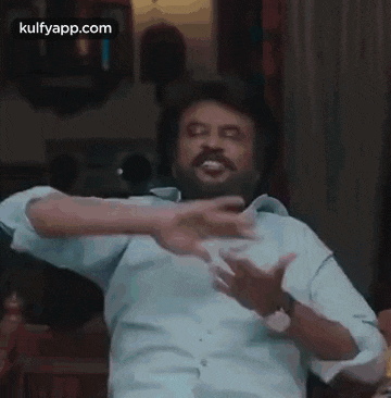 a man with a beard and mustache is making a funny face with his hands outstretched .