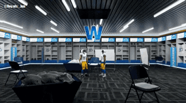 two football players standing in a locker room with the letter w on the ceiling