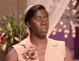a woman with a flower in her hair is making a funny face in front of flowers .